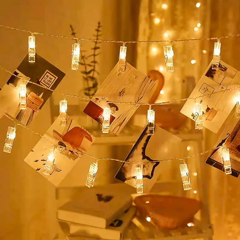 Warm white LED photo clip string lights with various photos hanging in a display