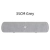 A grey silicone faucet drain mat with ridges and a central drain hole.