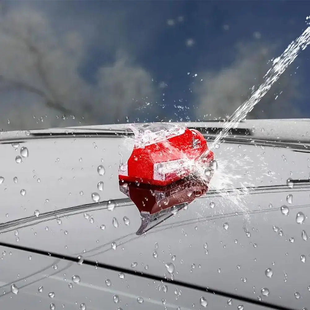 A red wind-powered LED antenna light is being activated by rain droplets on a car's surface.