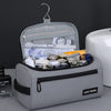 A light gray toiletry bag with a carry handle is open, displaying various grooming and skincare products.