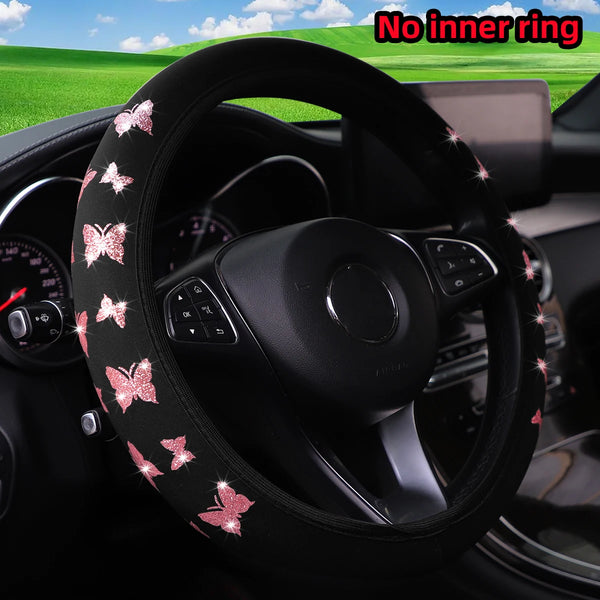 Black steering wheel cover with a glitter pink butterfly pattern installed in a car interior.
