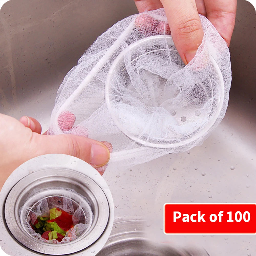 A hand is holding a clear mesh sink strainer bag filled with small, round, white silicone strainers.
