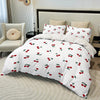 White duvet cover set with a red cherry print featuring various cherry designs and pillows on a bed.