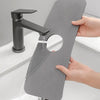 A black marble faucet drying mat is shown with a modern faucet dripping water onto the mat.