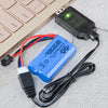 A blue battery pack and a black charging cable with a connector lying on a keyboard.