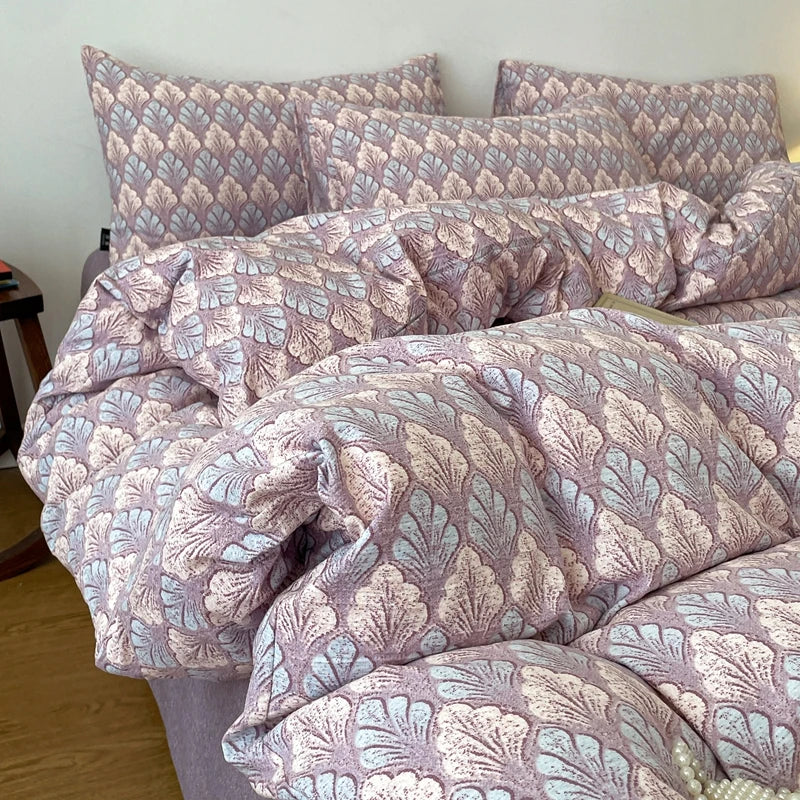 A set of soft printed duvet covers and pillowcases in a mauve and light blue floral pattern.
