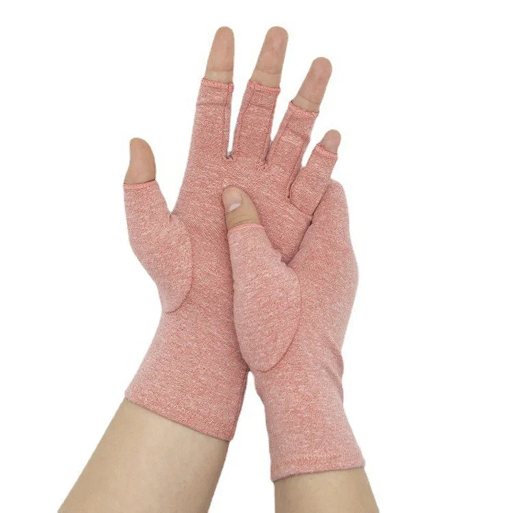 A pair of pink compression arthritis gloves with wrist support shown on a hand.