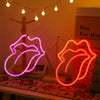 Neon sign shaped like lips glowing pink and orange on a wooden surface