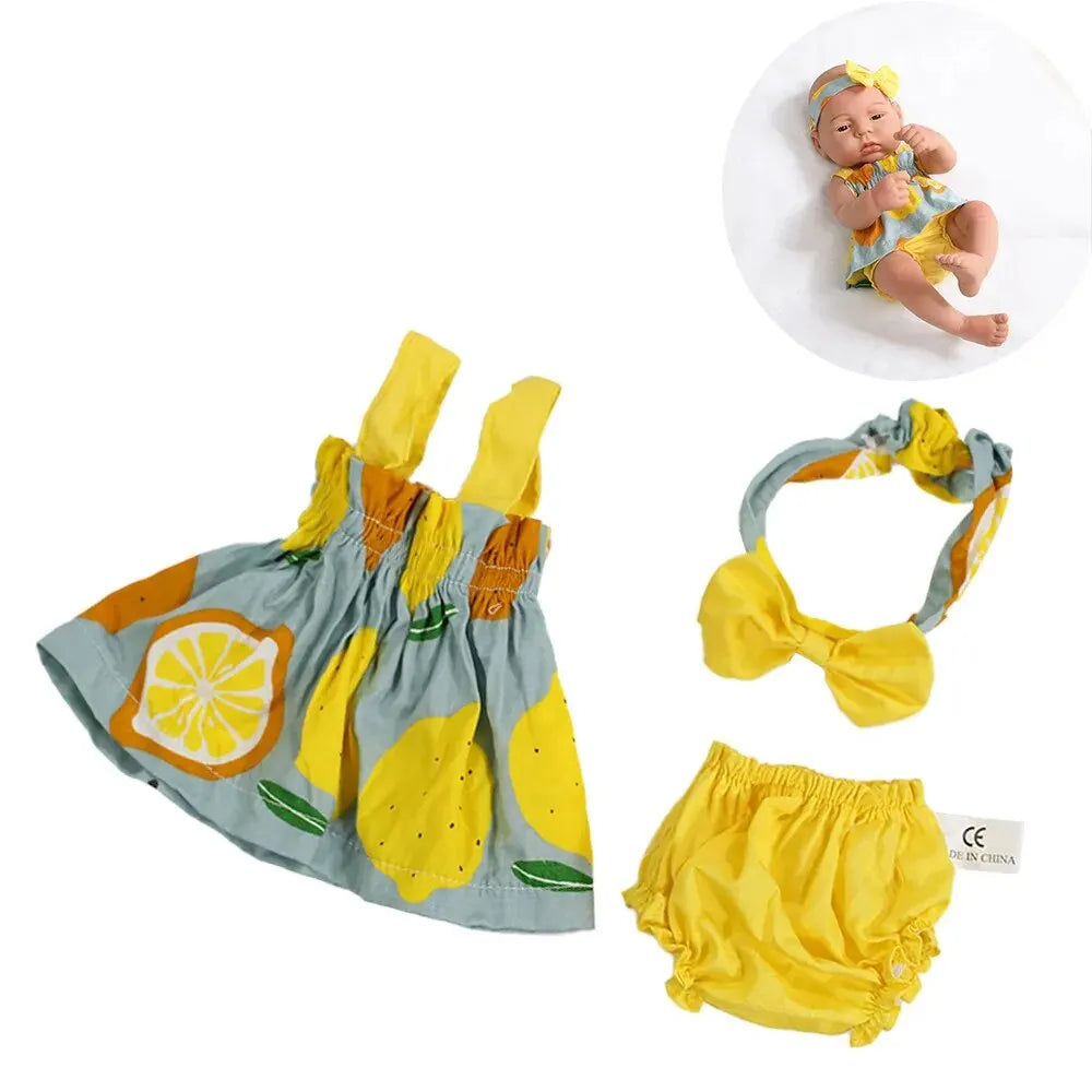 A set of three yellow and green outfits for a baby doll, including a doll and two clothing pieces.