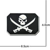 A black embroidered patch featuring a white skull and crossed swords with reflective accents.