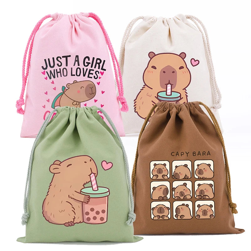 Three drawstring storage bags featuring cute capybara illustrations in pink, cream, and olive green.