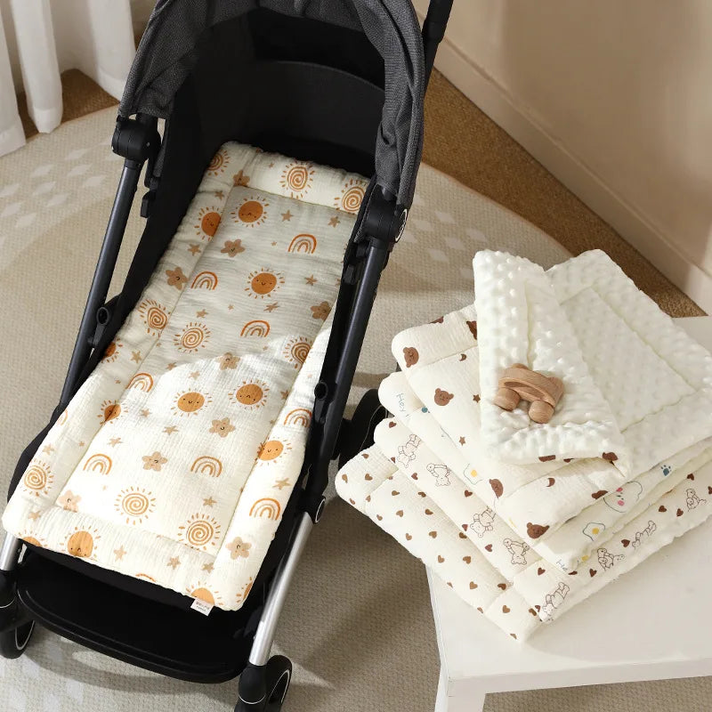 A white padded stroller seat cushion with a sunburst pattern is displayed next to a stack of similar cushions.