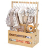 Wooden storage crate with a long handle holding baby clothing and toys.