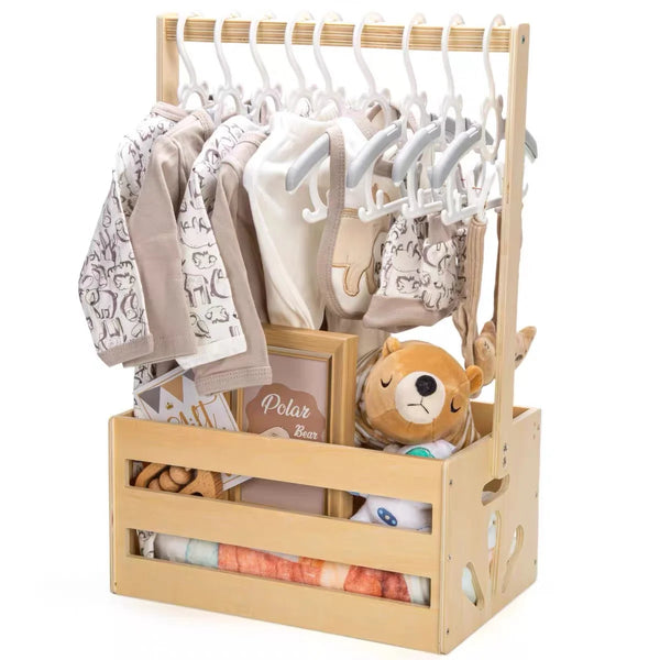 Wooden storage crate with a long handle holding baby clothing and toys.