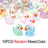 A collection of 10 random colored glitter resin duck figurines.