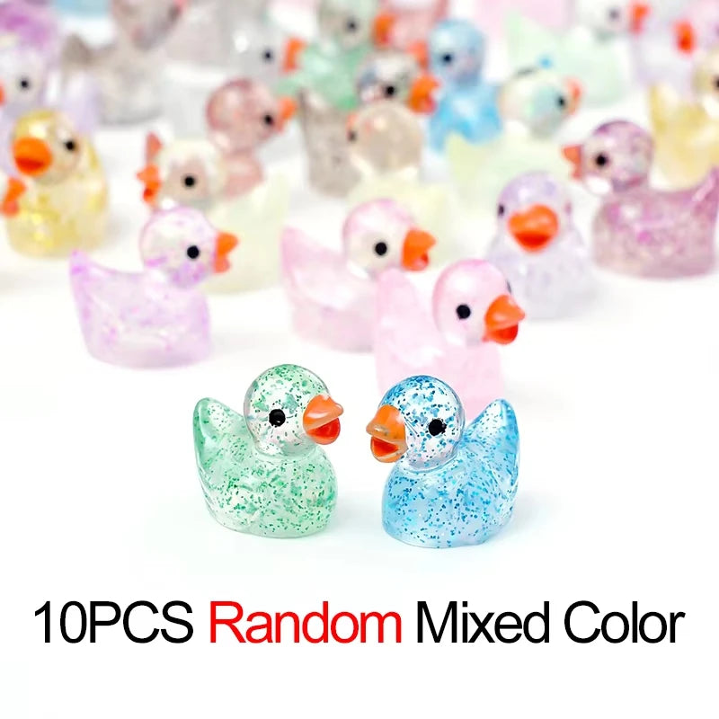 A collection of 10 random colored glitter resin duck figurines.