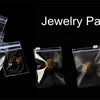 A collection of jewelry packaging bags, including clear resealable pouches holding various gold and silver accessories.