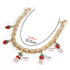 A gold-colored metal chain strap for handbags and purses with strawberry charms.