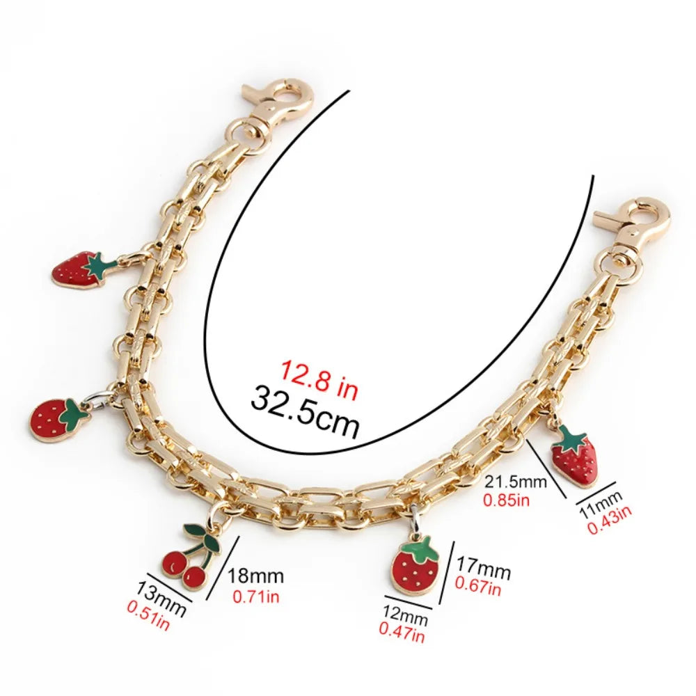 A gold-colored metal chain strap for handbags and purses with strawberry charms.
