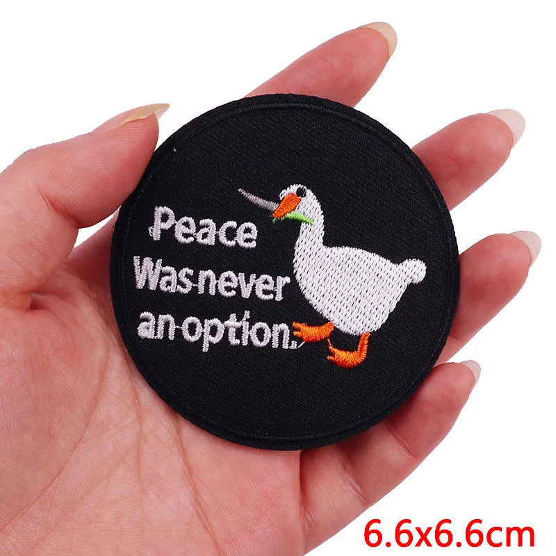 A black embroidery patch featuring a white duck with text that reads Peace Was never an option.