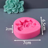 A pink silicone mold shaped like a rose flower, next to a green fabric flower.