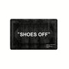 A black minimalist doormat with the text SHOES OFF engraved on it.