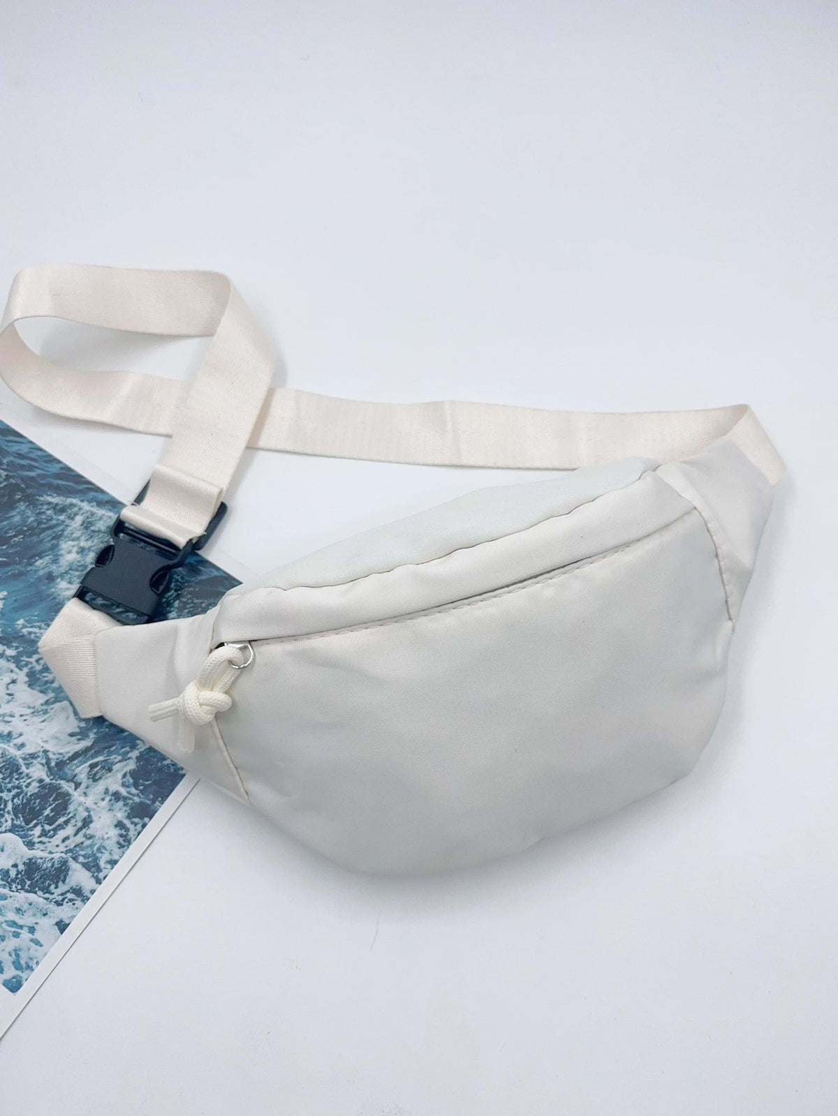 Bolso cruz de nylon blanco con correa beige claro, mostrado sobre fondo blanco.