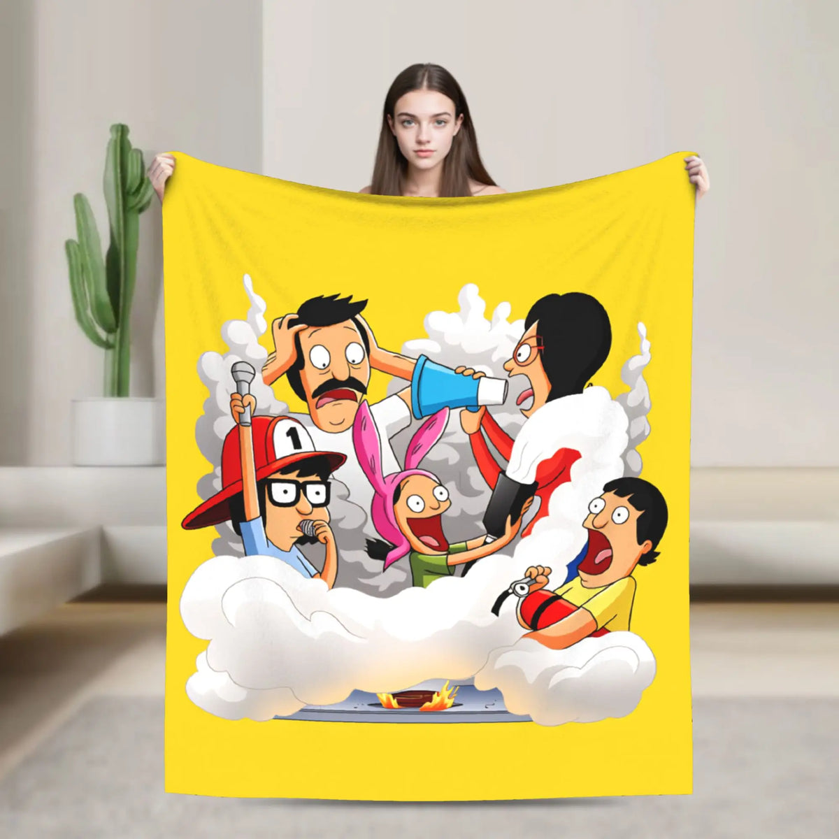 A yellow throw blanket featuring a cartoon illustration of characters in clouds.