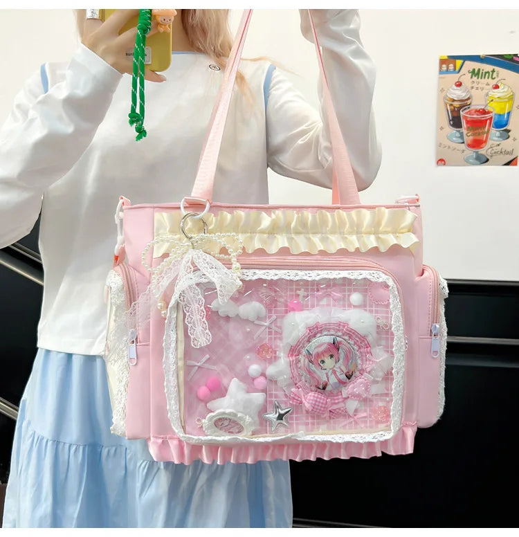 A pink transparent shoulder bag with white lace trim and a pink floral design is held by a person.