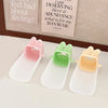 Three silicone faucet extenders in pink, green, and yellow for kids