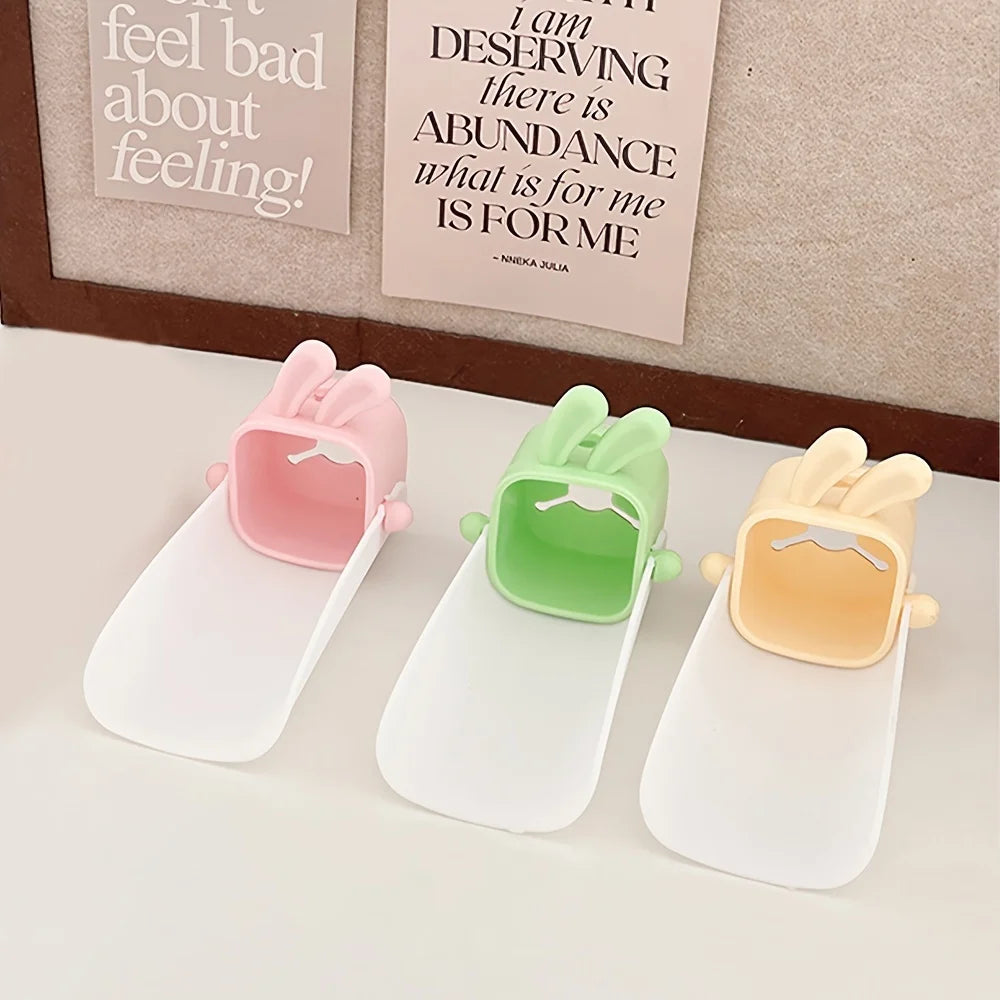Three silicone faucet extenders in pink, green, and yellow for kids