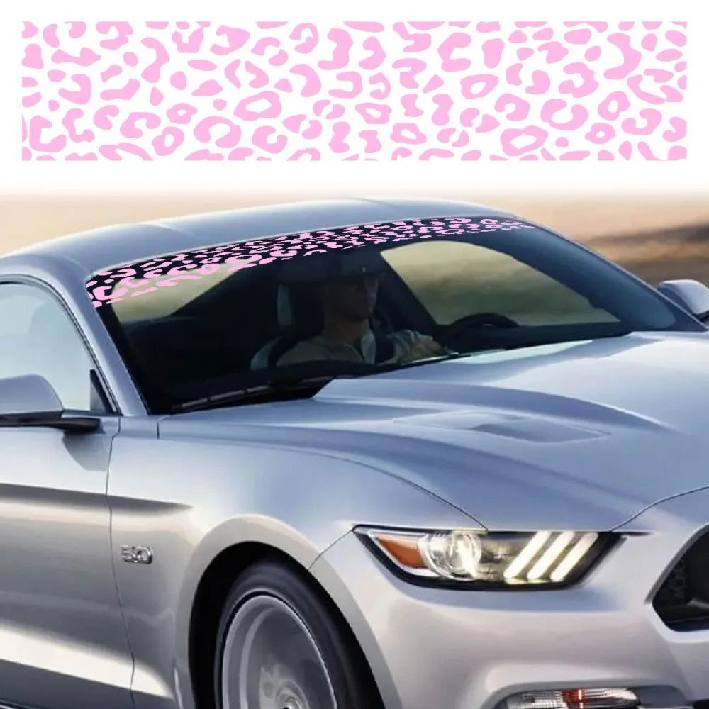 A silver car is shown with a leopard print sunshade decal strip applied to the windshield.
