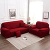 A deep red silky soft stretchable sofa cover displayed on a modern living room floor.