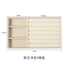 A beige velvet jewelry organizer tray with three detachable compartments.