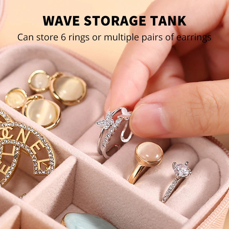 A hand is placing silver rings into a pink PU leather wave storage tank jewelry box.