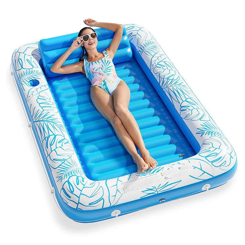 Une femme se détend sur un transat de piscine gonflable bleu avec un repose-tête, portant des lunettes de soleil.