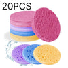 A stack of colorful compressed natural sponge pats, including pink, blue, purple, and yellow varieties.