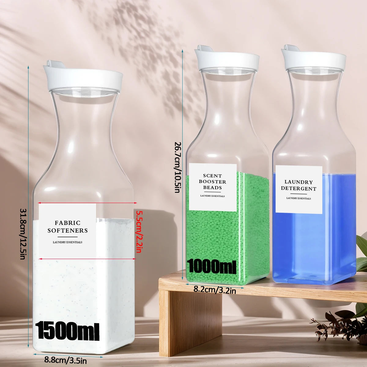 Three clear glass refillable laundry detergent dispenser bottles with white and green labels displayed on a wooden surface.