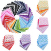 A bundle of colorful cotton fabric squares featuring various floral and dot patterns for patchwork and quilting projects.