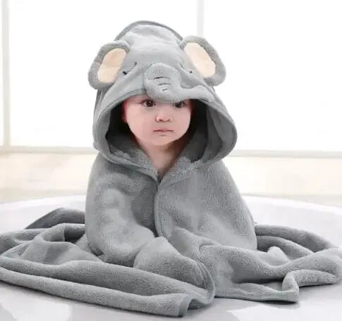 A baby wearing a gray, hooded towel with an elephant design is shown lying down.