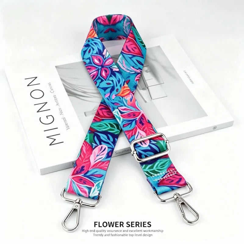 A floral patterned fabric strap for an elegant crossbody bag, featuring pink, blue, and green designs.