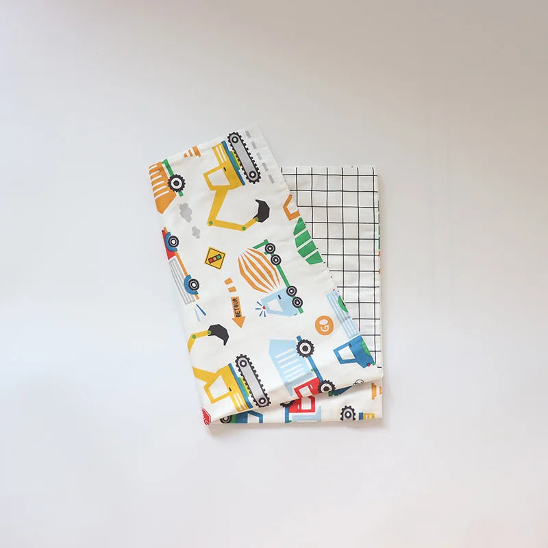 A white soft cotton baby pillowcase featuring a colorful cartoon design of various construction vehicles.