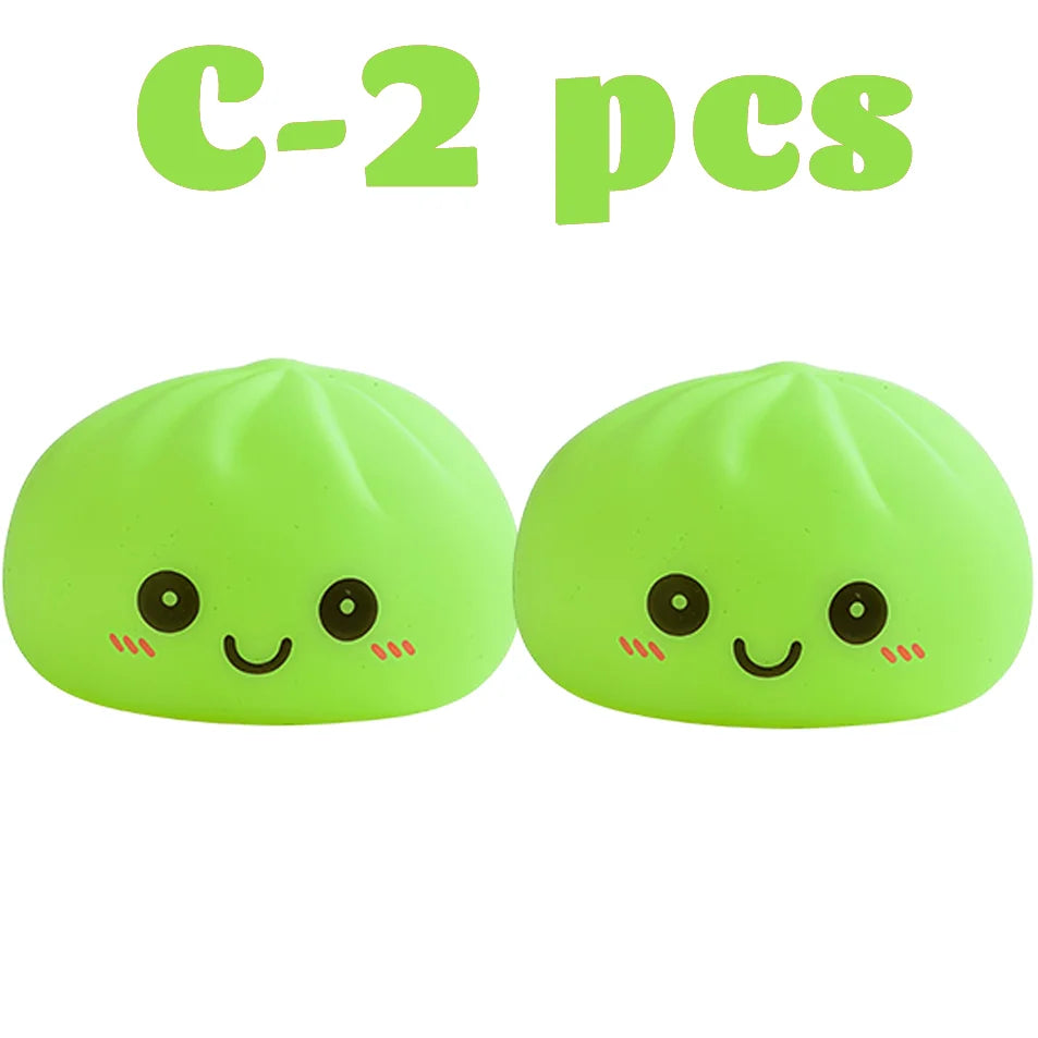 Dos juguetes suaves en color verde lima con forma de dumplings sonrientes