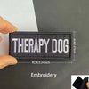 Black embroidered patch with white text Therapy Dog and reflective details
