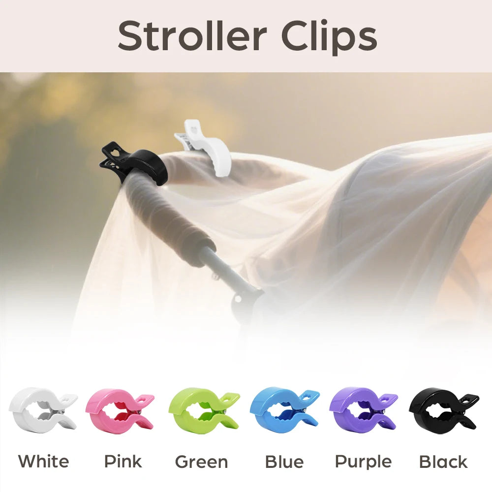 A set of colorful stroller clips in white, pink, green, blue, purple, and black are shown attached to a light-colored fabric.