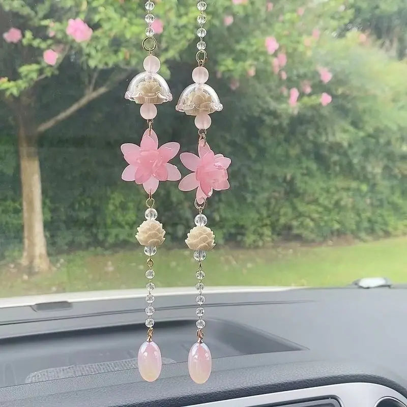 A pair of pink lotus car pendants featuring layered floral designs and clear beads.