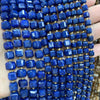A close-up of strands of deep blue natural stone square faceted beads for jewelry making