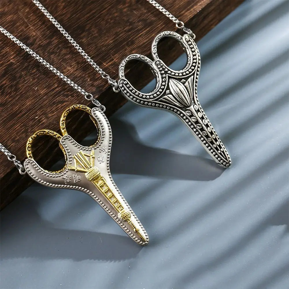 A pair of vintage stainless steel sewing scissors with gold accents hanging from a silver chain.