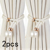 A set of two pearl and rope curtain tie-backs in off-white fabric with gold accents.
