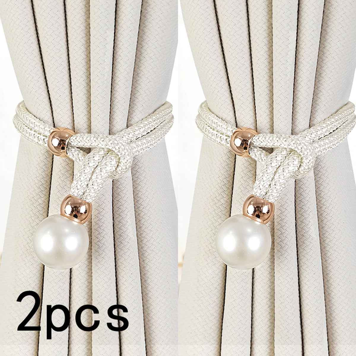 A set of two pearl and rope curtain tie-backs in off-white fabric with gold accents.